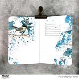 Open notebook with blue splatter design and bird illustration on a gray background, featuring the brand 'Arden Creative Studio'.