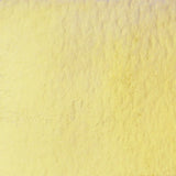 A close-up textured swatch of pale yellow material, resembling a fabric or plaster surface.
