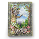 Decorative notebook cover with a forest-themed design featuring a face among trees and mushrooms.