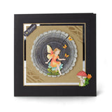 Framed artwork of a fairy sitting inside a tree stump with mushrooms and flowers.