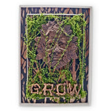 Decorative wall art with a green man design and 'GROW' text, framed with natural elements.