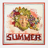 Decorative wall art with a face surrounded by flowers and the word 'Summer' on a colorful background.