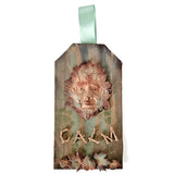 Decorative wall hanging with a face design and 'CALM' text on a striped background.