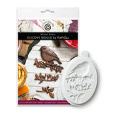 A white oval silicone mould for winter robin clay sculpting, shown next to its retail packaging card by Kath Sue. The packaging features a photo of a winter robin on a branch and the text 'Winter Robin Silicone Mould by Kath Sue'.