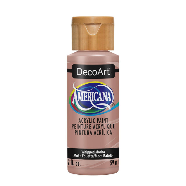 A bottle of DecoArt Americana acrylic paint in the color Whipped Mocha, featuring a metallic pinkish-beige paint inside and a gold cap, shown on a plain white background.