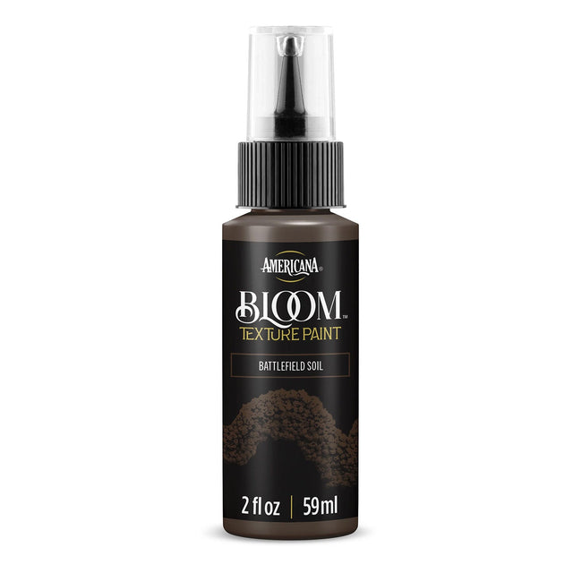 A bottle of Americana BLOOM Textured Paint in Battlefield Soil, featuring a black spray cap and a textured brown paint container on a white background.