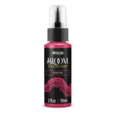 A bottle of Americana BLOOM Textured Paint in the shade Desert Petal, featuring a black label with pink and gold text and a textured pink paint design, on a white background.
