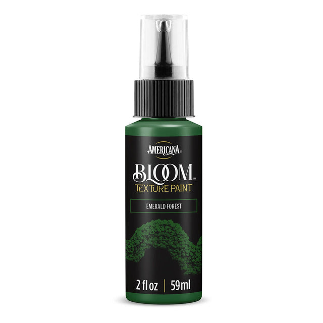 A bottle of Americana BLOOM Textured Paint in Emerald Forest, featuring a dark green body, black cap, and a black label with white and gold text.