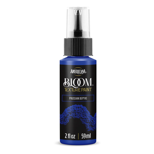 A bottle of Americana BLOOM Texture Paint in the color 'Prussian Depths', featuring a black label with blue and gold text and a blue paint texture graphic at the bottom, on a white background.