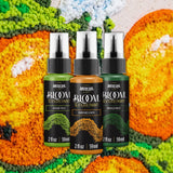 Three bottles of Americana BLOOM Texture Paint arranged in a row against a colorful, textured background. The bottles contain green, orange-brown, and dark green paint, labeled 'Weary Pile,' 'Balanced Earth,' and 'Emerald Forest.
