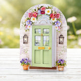 Decorative fairy door with floral arch and potted plants on a wooden surface.
