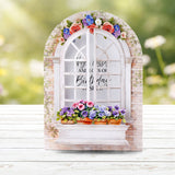 Decorative window frame with flowers and text on a blurred natural background