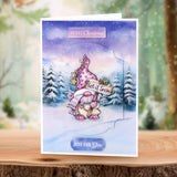 Christmas card with a gnome and 'Let it Snow' sign on a snowy landscape background.