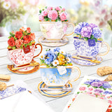 Decorative teacups with floral arrangements on a table outdoors.