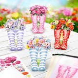 Colorful rain boots with floral arrangements on a wooden surface.