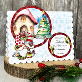 Christmas-themed greeting card with a gnome, house, and tree on a wooden surface.