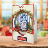 Christmas-themed greeting card with a gnome and festive decorations on a wooden surface.