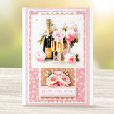 Greeting card with champagne bottles, glasses, and flowers on a decorative pink border.