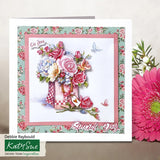 A handmade greeting card with a floral and bouquet design, displayed next to a large pink gerbera daisy. The card features a pink border, a green floral patterned background, and a central illustration of a pink checkered vase filled with pink, red, and blue flowers, with the text 'On You' and 'Special Day'.