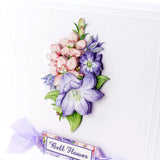 A close-up of a decorative card featuring a raised floral arrangement of pink and purple bell flowers with green leaves, plus a small ribbon label reading 'Bell Flower' on a white card background.