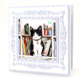 Illustration of a black and white cat sitting on a bookshelf with decorative frame