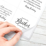 Hand holding a birthday card with personalized text on a wooden surface