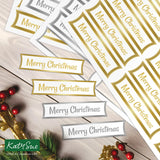 Merry Christmas labels on a wooden surface with decorative elements.