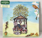 Card with a treehouse, flowers, and bird design by Katy Sue Designs on a blue background.