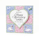 Anniversary card with swans, butterflies, and floral patterns on a white background