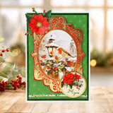 Decorative Christmas card with red poinsettias and a lantern design on a wooden surface.