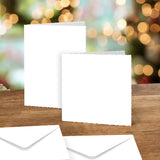 Two white cards on a wooden surface with blurred lights in the background