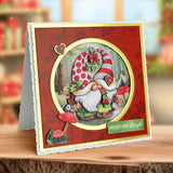 Decorative Christmas card with a gnome design on a wooden surface.