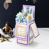 Decorative holiday card with floral design and gift box on a dark background