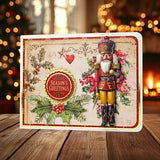 A rectangular Christmas greeting card with a nutcracker illustration, holly leaves, red berries, and a round 'Season's Greetings' badge, displayed on a wooden surface with blurred holiday lights in the background.