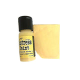 Bottle of Tim Holtz Distress Paint with a swatch of yellow color on a white background